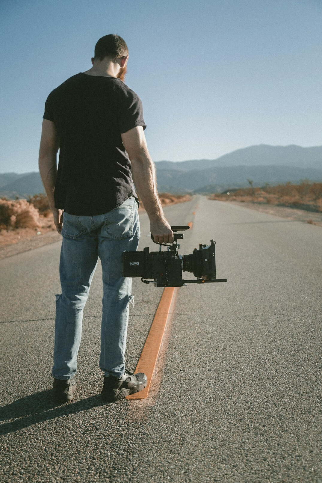 Camera operator filming with a shoulder-mounted broadcast camera