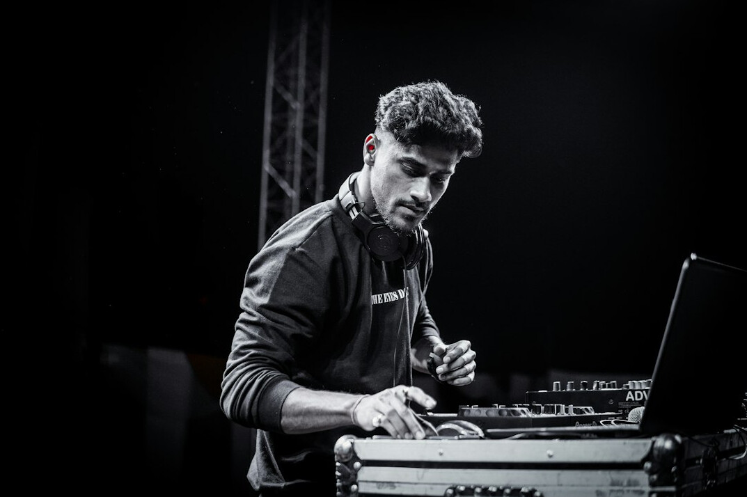Sound engineer adjusting levels on an audio mixing laptop setup